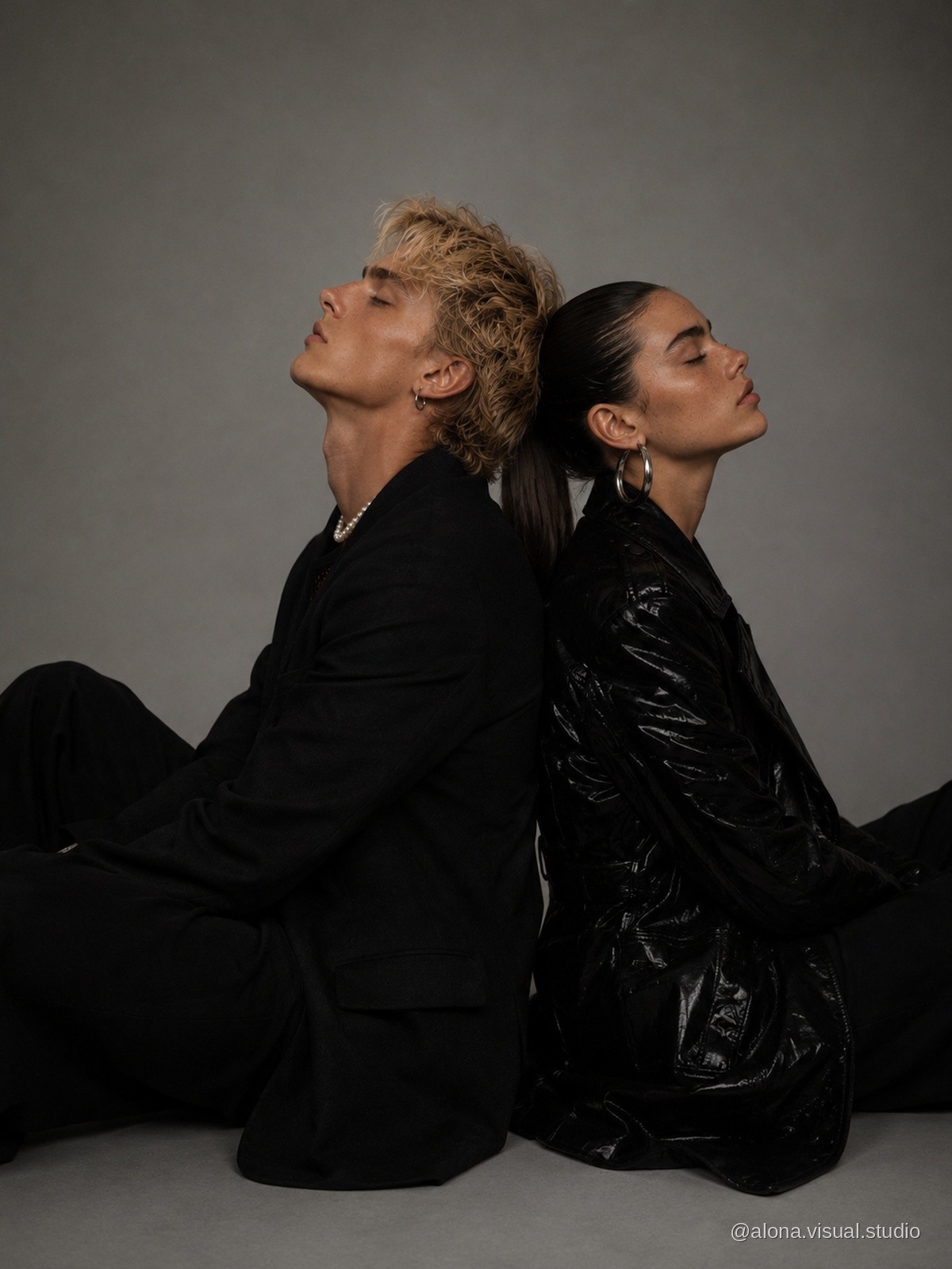 Fashion couple seated back to back